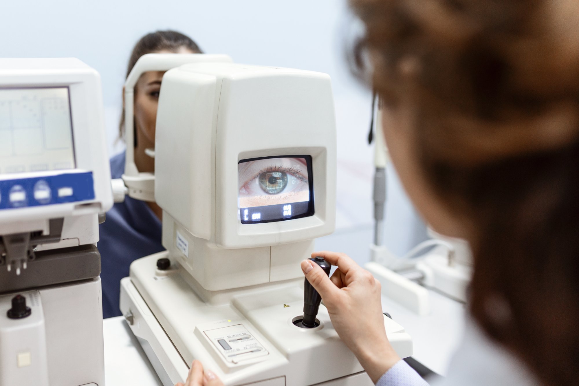 Optometrist using advanced diagnostic equipment on a patient